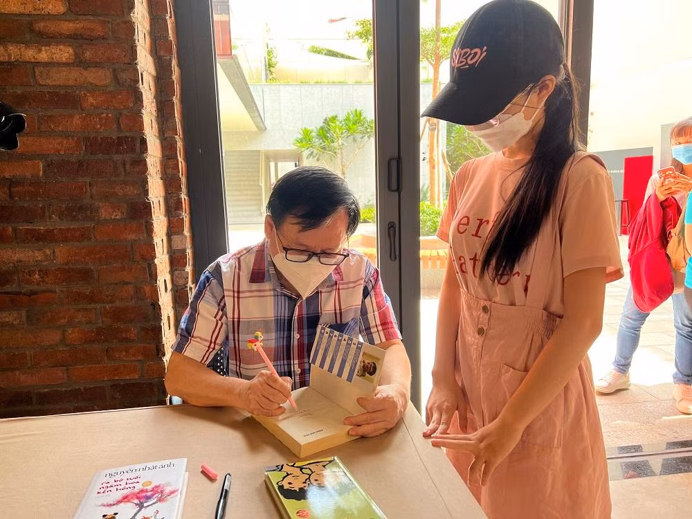 Nhà văn Nguyễn Nhật Ánh ký tặng độc giả tại buổi họp báo ra mắt sách nói. Nhà văn Nguyễn Nhật Ánh ký tặng độc giả tại buổi họp báo ra mắt sách nói.