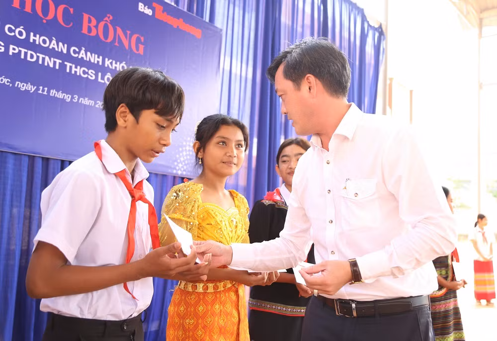 Ông Nguyễn Trần Chí Linh, Phó Giám đốc Công ty Điện lực Bình Phước trao học bổng, tiếp lửa cho những mầm non tương lai của đất nước. (Ảnh: Ngô Tùng)