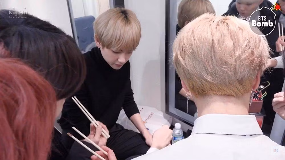 Cả nhóm BTS chụm đầu lại, giơ đũa lên, chuẩn bị măm măm bánh kem!