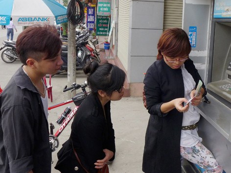 Người dân ngạc nhiên hỏi nhau về thu phí khi in hóa đơn sao kê tài khoản Ảnh: Xuân Phú 