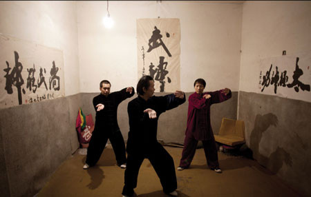 Võ sư Yan (giữa) và các học trò luyện tập Wushu trong căn phòng tập luyện “ngầm” ở tây Bắc Kinh, 28-2-2011. Yan từ chối cho biết tên đây đủ. Anh điều hành hầm tránh bom này, nơi có 130 phòng cho thuê cùng với giấc mơ mở rộng môn võ wushu và thái cực quyền