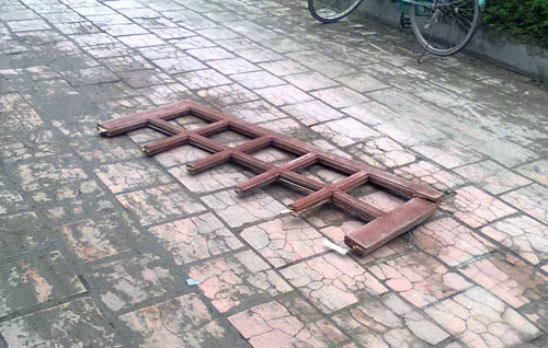 Cánh cửa sổ phía sau căn phòng văng xuống sân trụ sở ủy ban sau vụ nổ. Ảnh: Văn Hải