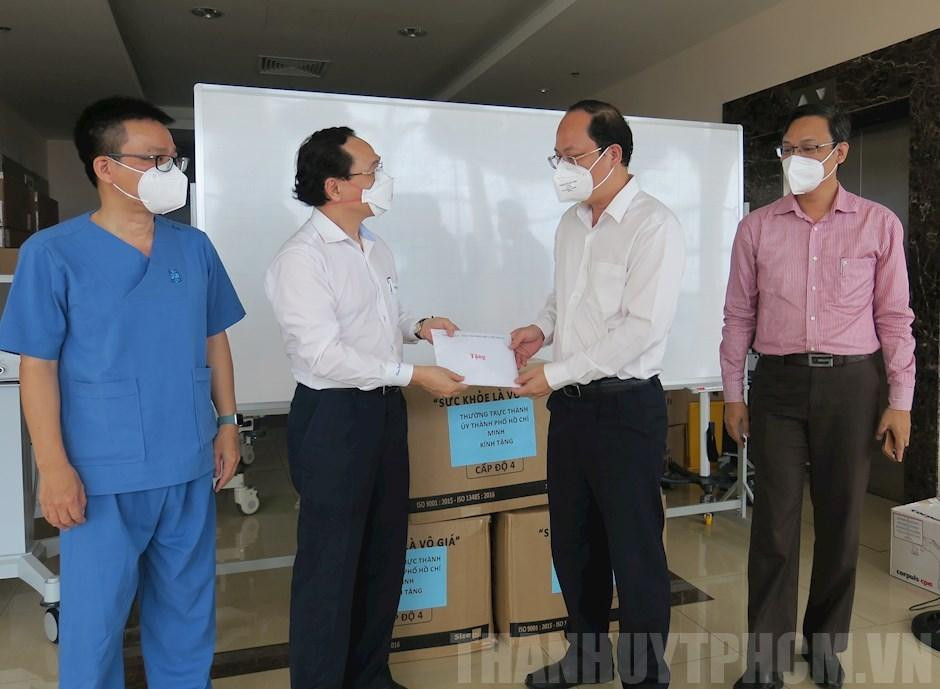 Phó Bí thư Thành ủy Nguyễn Hồ Hải (thứ 2 từ phải qua) tặng quà cho các y bác sỹ. Ảnh: Thành ủy TPHCM