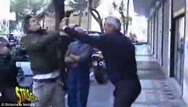 Gã bác sĩ đang cầm đoạn dây cáp tấn công một phóng viên ghi hình 