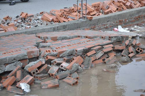 Bức tường đang xây dở của tòa nhà cao tầng bị người dân hò nhau đẩy đổ