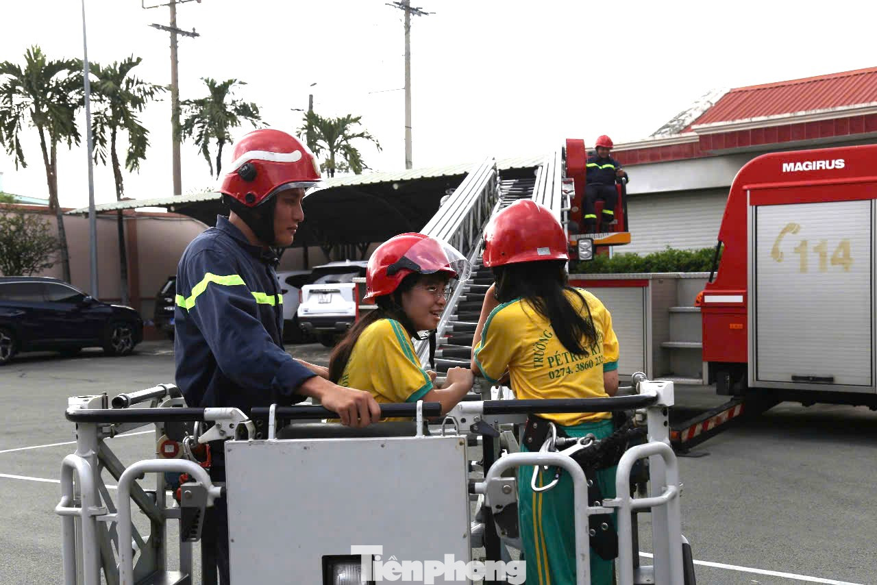 Các em học sinh trải nghiệm trên xe thang cứu hỏa.