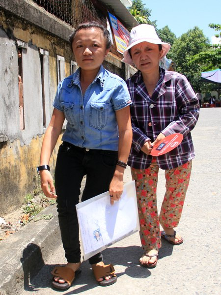 Hai mẹ con cùng mắc chứng xương thủy tinh trên đường về ký túc xá sau khi kết thúc môn Toán. Ảnh: Nguyễn Đông