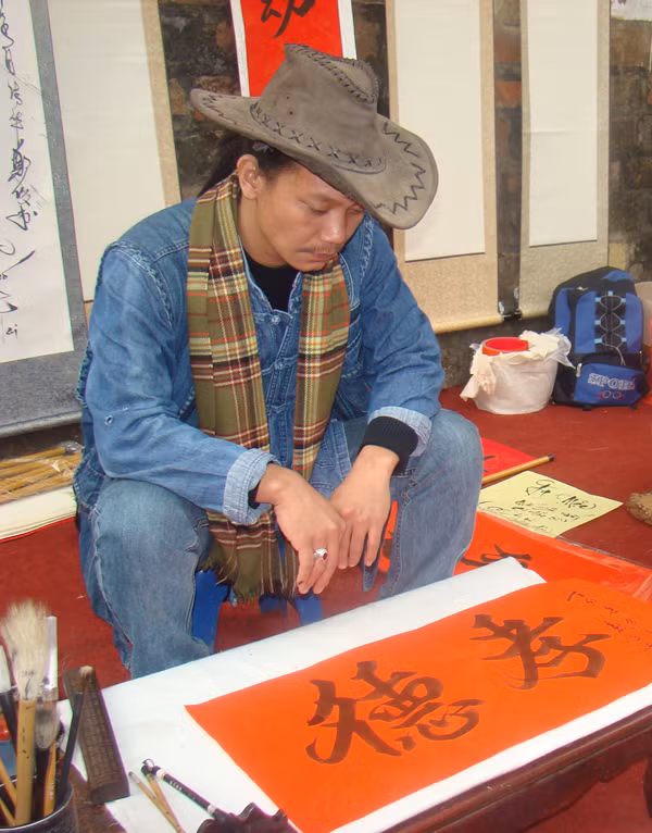 Một thư pháp gia với trang phục kiểu cao bồi