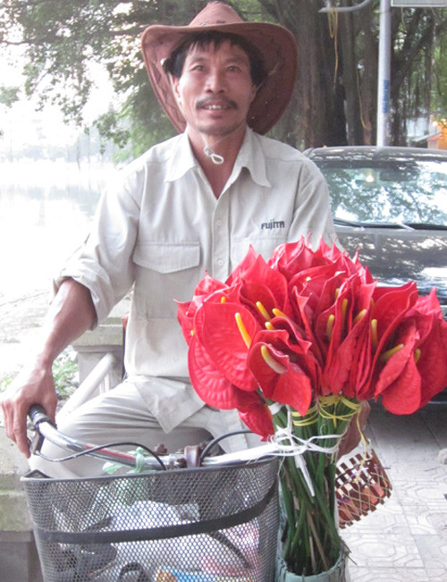 Ông Bốn Râu hàng ngày đạp xe đi bán hoa giả. Ảnh: V.T.. Ông Bốn Râu hàng ngày đạp xe đi bán hoa giả. Ảnh: V.T.