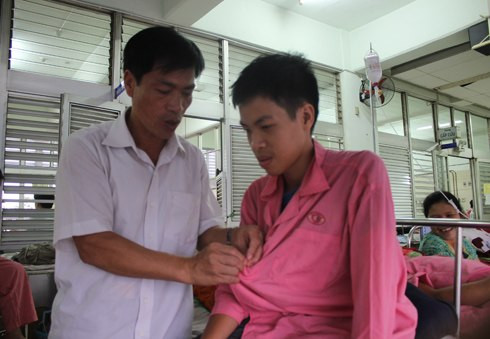  Anh Nguyễn Viết Thuân đang chăm con ở Bệnh viện Chợ Rẫy. Ảnh: Nguyễn Loan