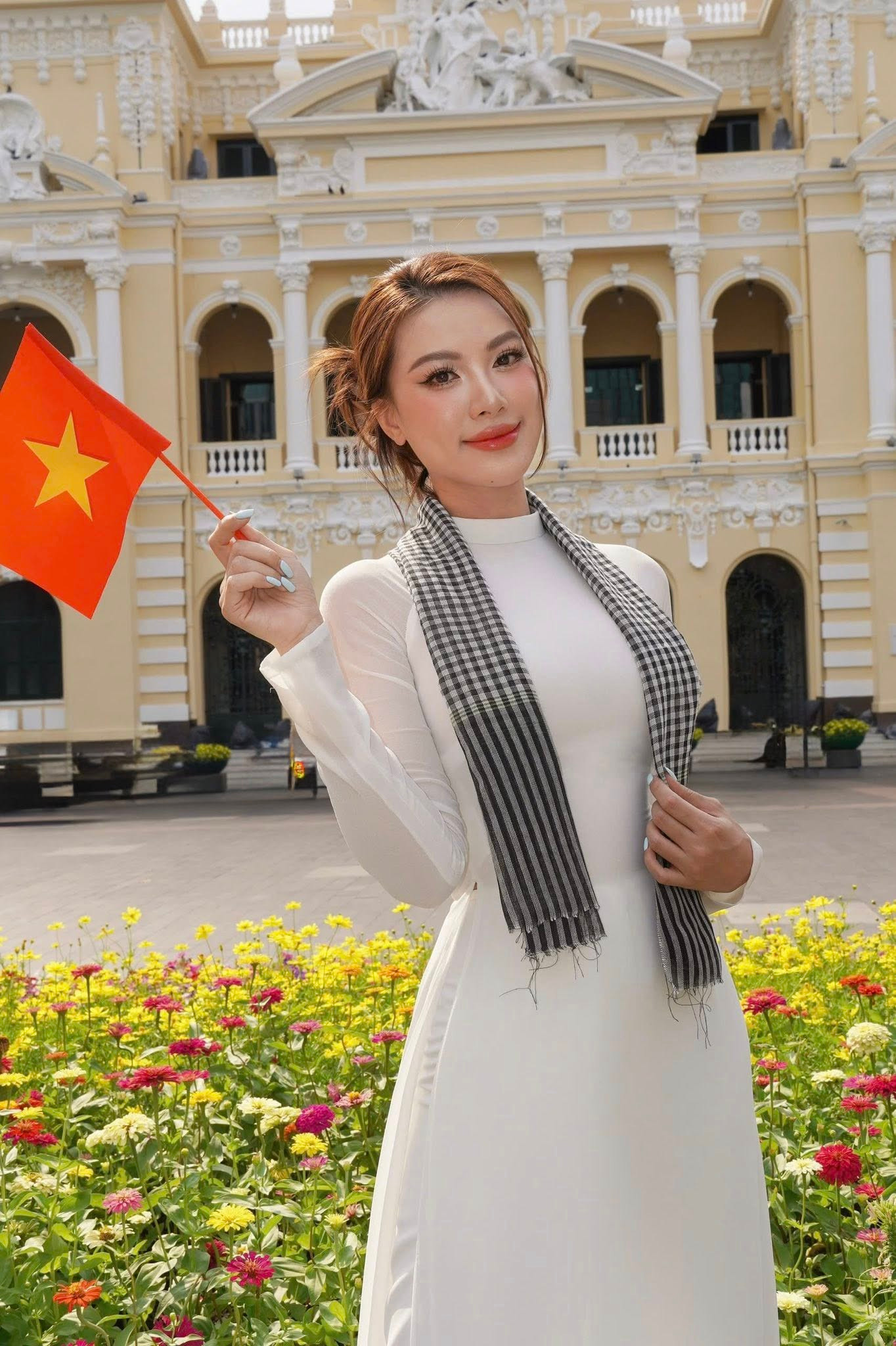 Á hậu Kim Duyên mặc áo dài trắng, mang theo chiến khăn rằn đặc trưng của người con Nam Bộ để hòa cùng không khí tưng bừng chào mừng đại lễ 30/4 ở những địa điểm nổi tiếng tại TPHCM.