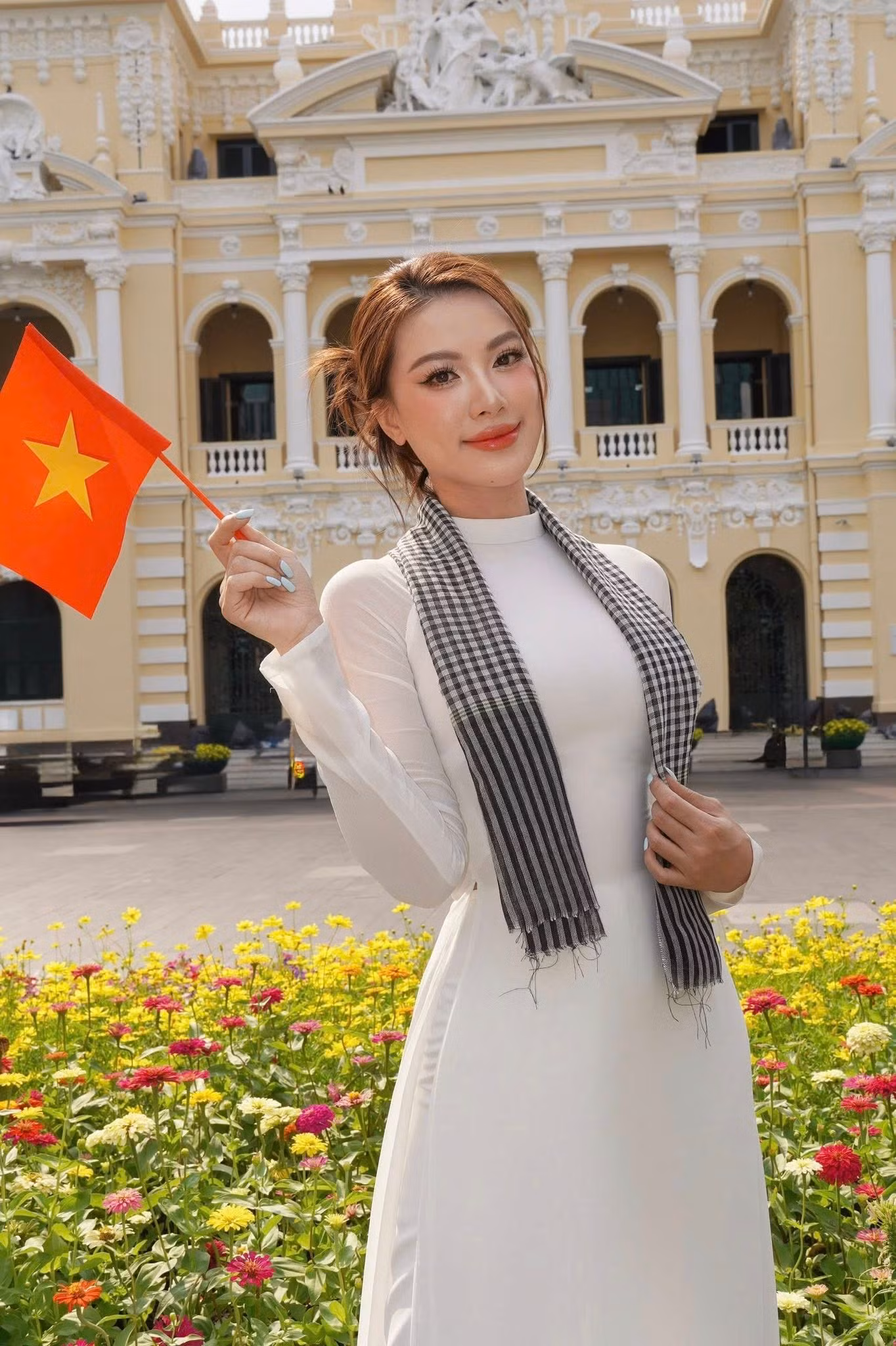 Á hậu Kim Duyên mặc áo dài trắng, mang theo chiến khăn rằn đặc trưng của người con Nam Bộ để hòa cùng không khí tưng bừng chào mừng đại lễ 30/4 ở những địa điểm nổi tiếng tại TPHCM.