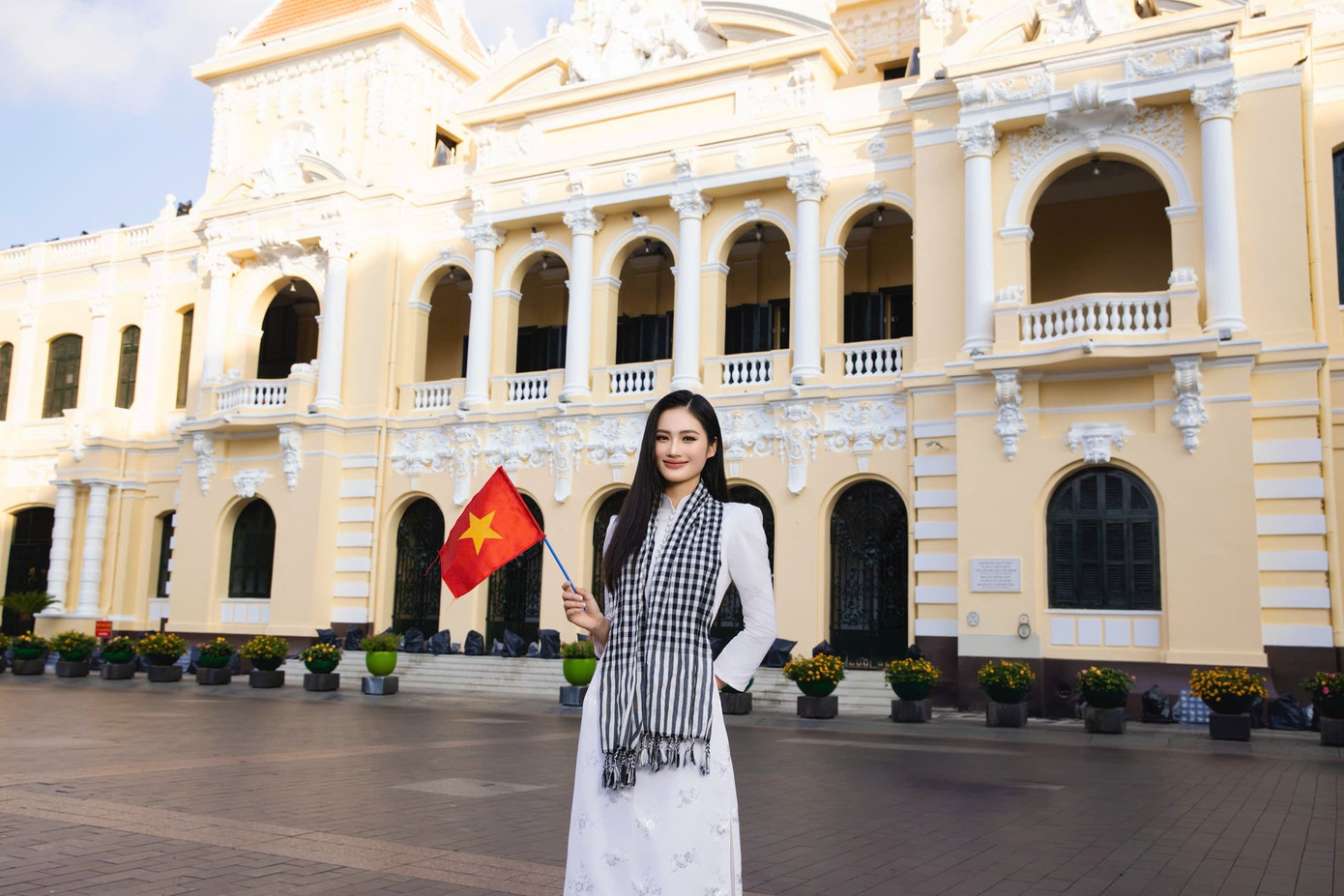 Hoa hậu Ý Nhi ghi lại nhiều khoảnh khắc với áo dài trắng và khăn rằn tại Dinh Độc Lập và UBND thành phố.