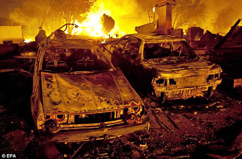 Những chiếc xe đỗ trên phố bị thiêu hủy như trong một vụ đánh bom. Hàng trăm người địa phương lâm vào cảnh mất nhà phải qua đêm tại trung tâm cứu trợ - Ảnh: EPA