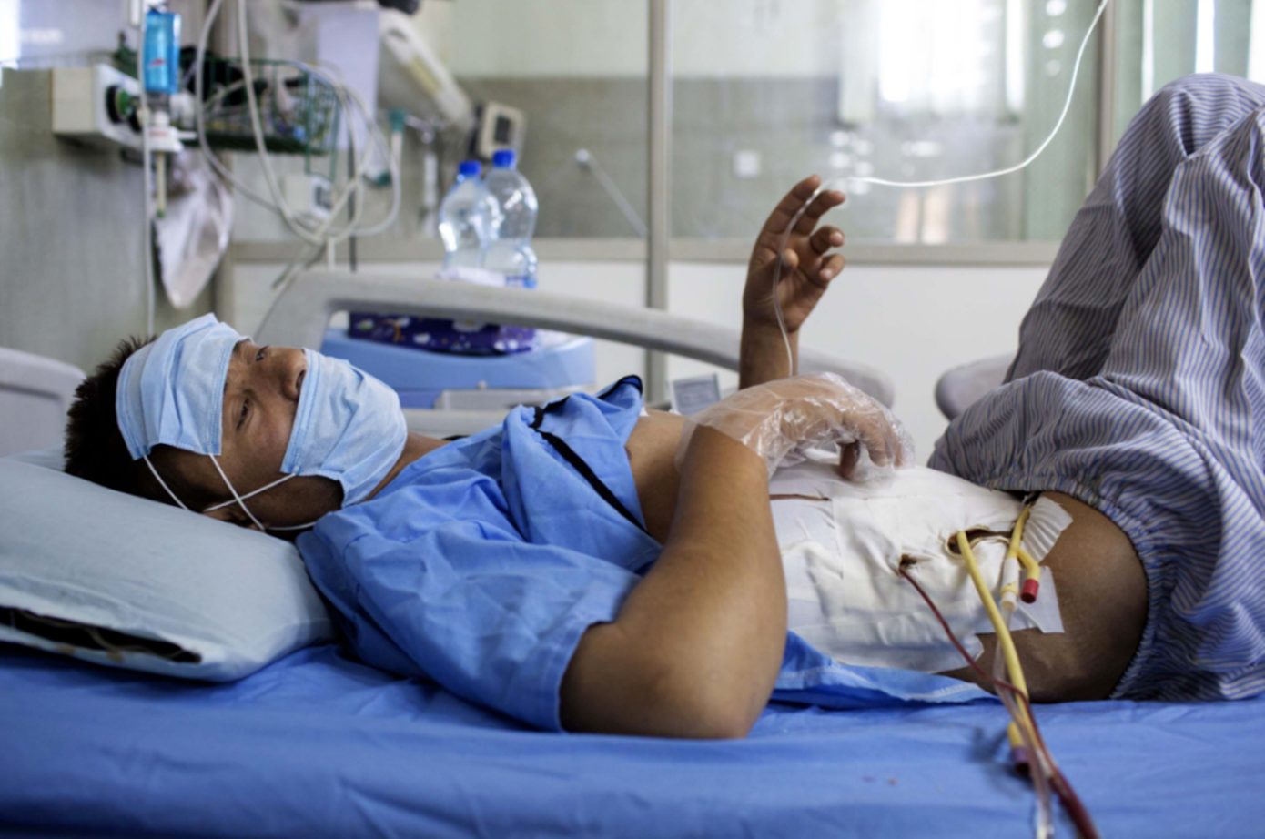 Một người đàn ông bán thận trên giường mổ.