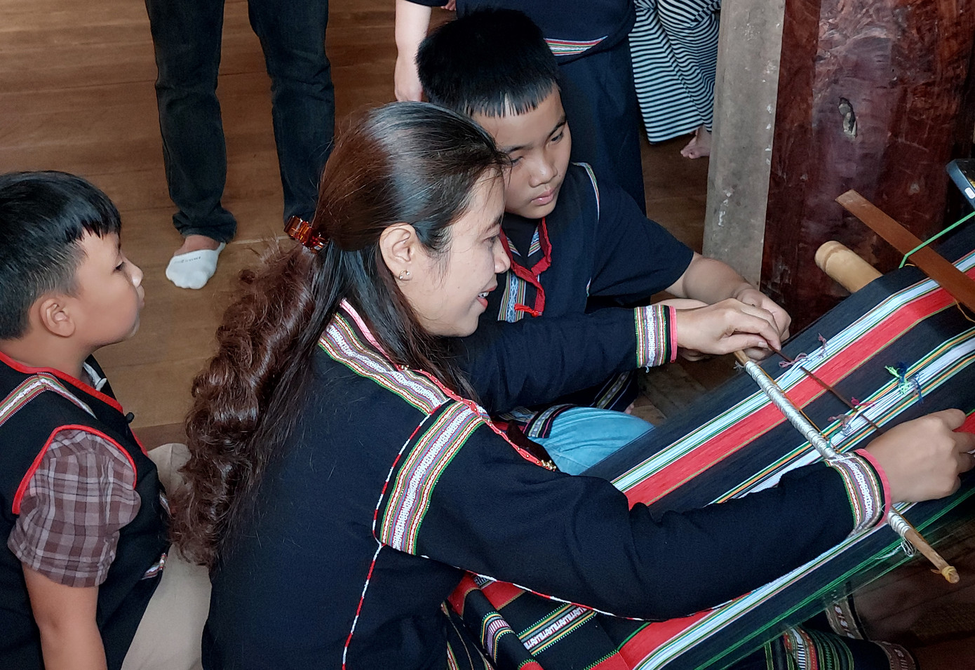 Chị H Min hướng dẫn cách dệt thổ cẩm cho các khách du lịch nhí Chị H Min hướng dẫn cách dệt thổ cẩm cho các khách du lịch nhí