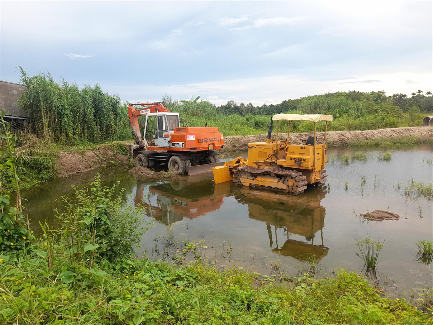 Máy móc nằm phơi sương tại công trường khu vực điểm giao cao tốc với đường Nam Sông Hậu (quận Cái Răng, TP Cần Thơ)
