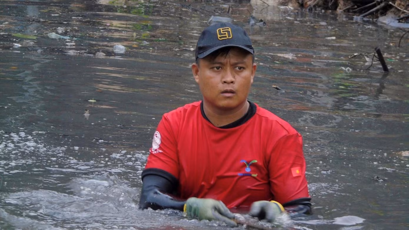 Đoàn Văn Tố lội dưới kênh vớt rác. Ảnh: H.C Đoàn Văn Tố lội dưới kênh vớt rác. Ảnh: H.C