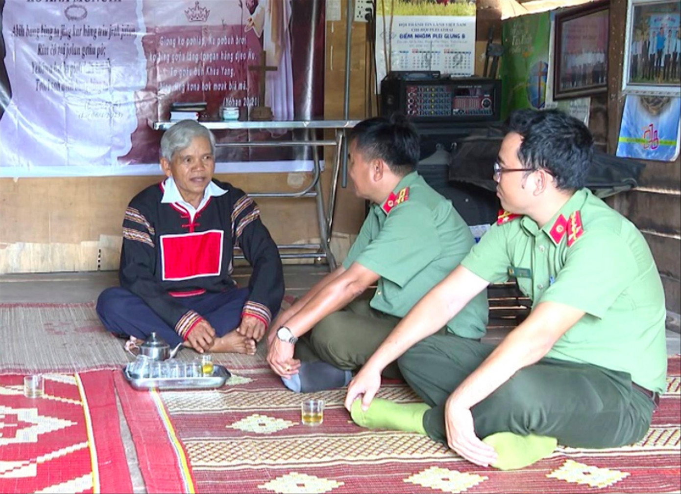 Ông Nay Ku và cán bộ công an huyện trò chuyện.