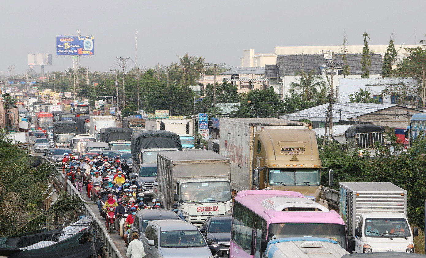 Quốc lộ 1 đoạn qua huyện Cái Bè (Tiền Giang) thường xuyên ùn tắc giao thông vào giờ cao điểm do xe container, xe tải nặng chở hàng hóa nông sản, lúa gạo lên TPHCM. Ảnh: Nhật Huy