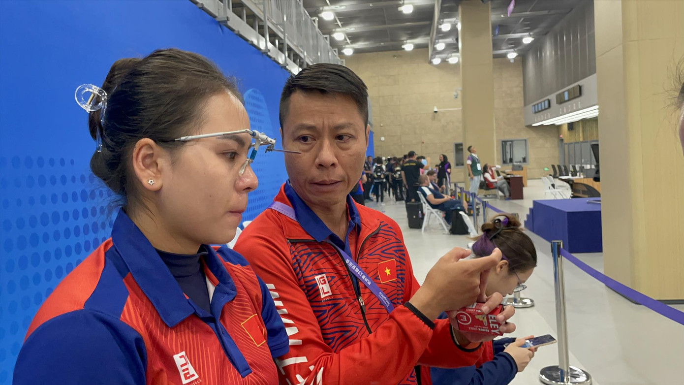 HLV Trần Quốc Cường động viên xạ thủ Trịnh Thu Vinh sau phần thi 25m súng ngắn thể thao sáng 27/9. Ảnh: Ngọc Khuê