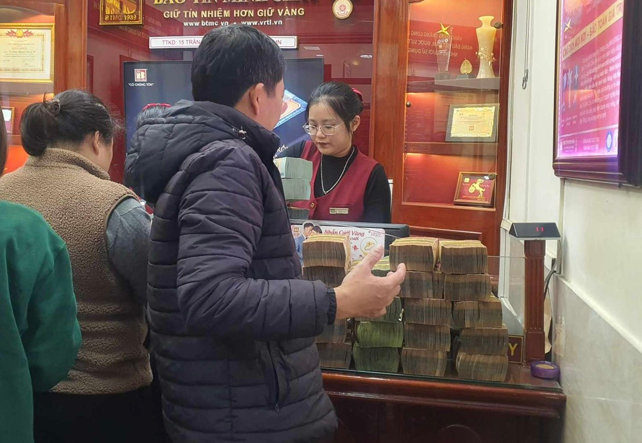 Một người dân xếp tiền giao cho nhân viên kiểm đếm khi mua vàng ngày 26/12 Một người dân xếp tiền giao cho nhân viên kiểm đếm khi mua vàng ngày 26/12