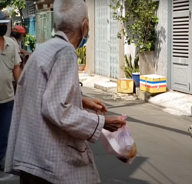 Cụ ông đứng gãi khi nhận cơm từ thiện bị nhắc nhở vì &quot;chỗ phát cơm linh thiêng&quot;.