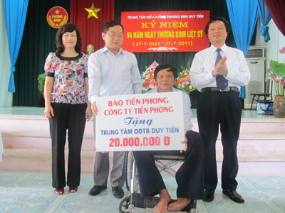 Ông Lê Xuân Sơn và bà Kim Chung (bên trái)tặng quà cho đại diện trung tâm