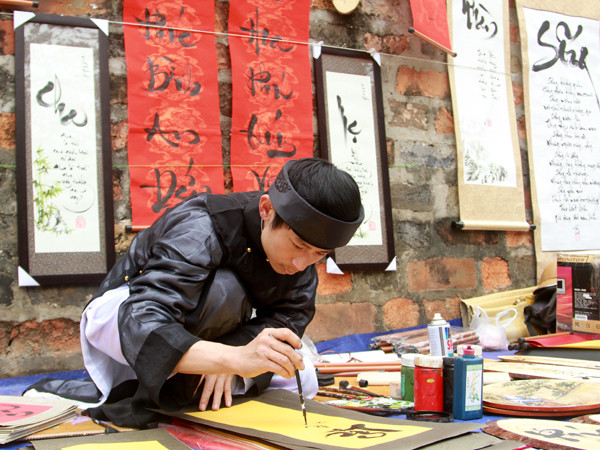 Ông đồ ét-vê Đông Phong thủ bút cho chữ