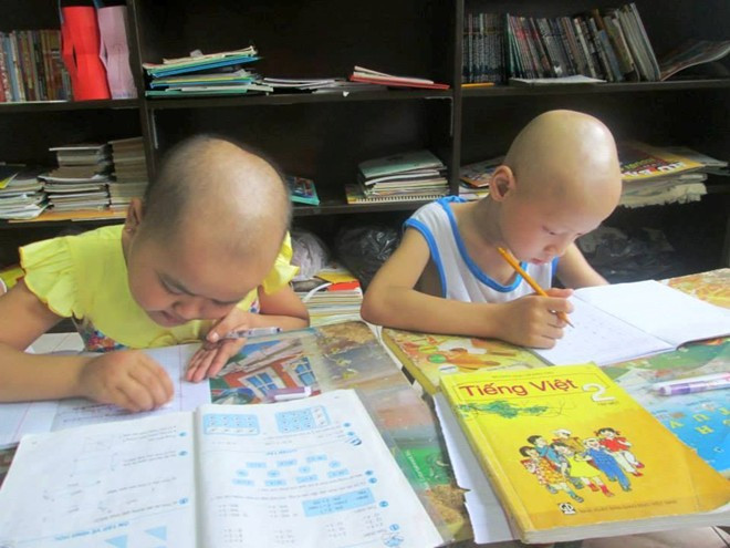 Bé Hồng Nhung và Anh Dũng đang chăm chỉ tập viết