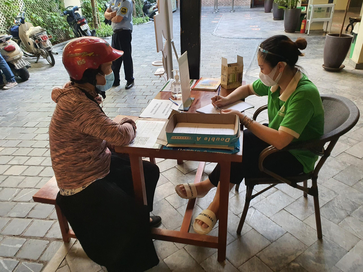 Tại cửa hàng Kem Tràng Tiền, những khách hàng không có điện thoại thông minh được khai báo y tế trực tiếp