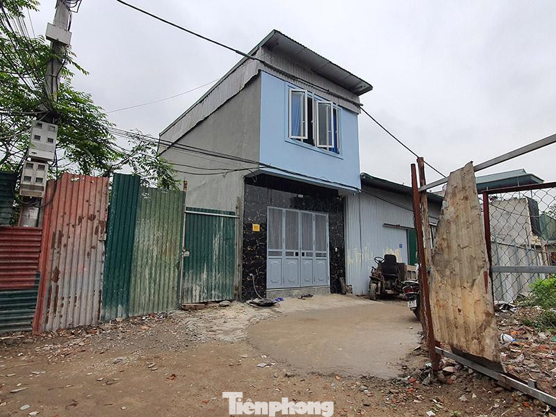 Bên trong vỏ bọc này, máy trộn, cẩu kéo vật liệu, công nhân hoạt động rầm rộ.