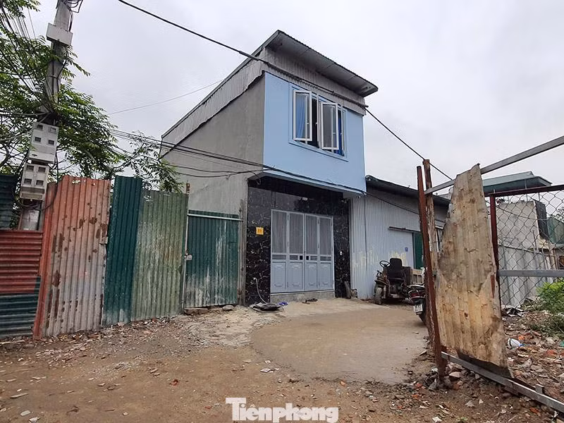 Bên trong vỏ bọc này, máy trộn, cẩu kéo vật liệu, công nhân hoạt động rầm rộ.