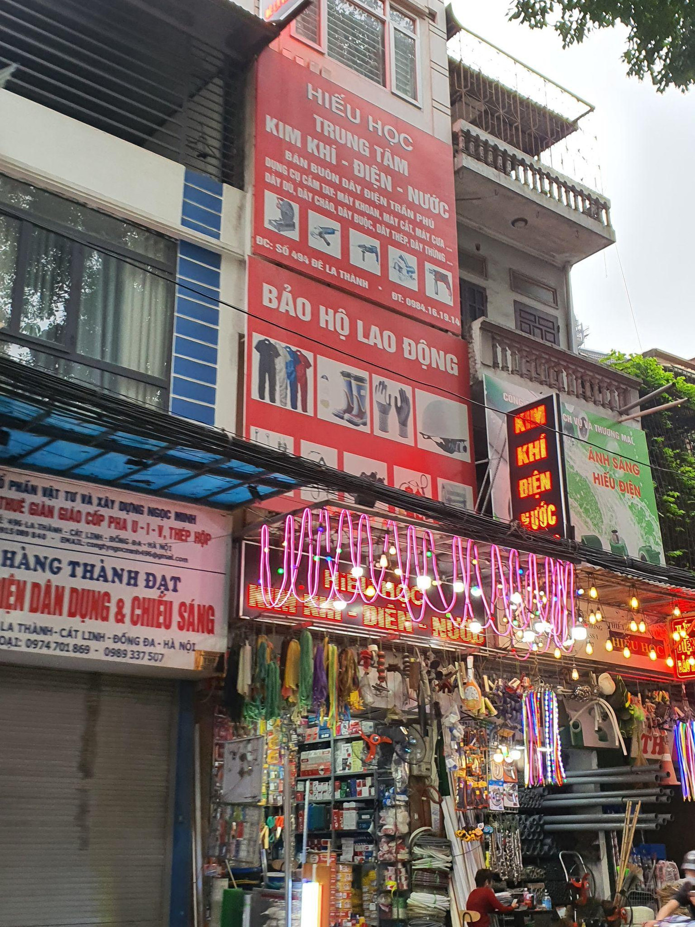 Trên đường Đê La Thành, có những cửa hàng bán đồ điện kín tầng 1 - nguy cơ cao về chập cháy, phía bên trên lại bị bịt kín bởi các biển hiệu, vô cùng nguy hiểm.