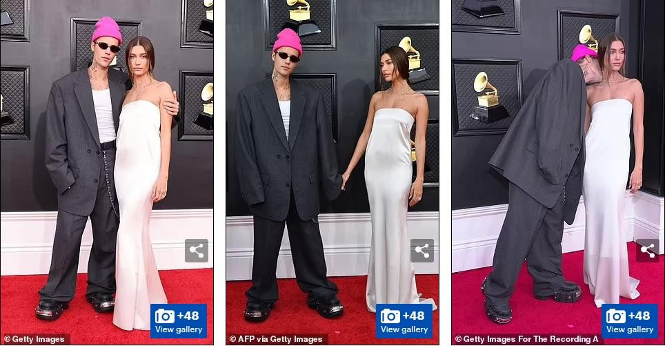 Justin Bieber diện bộ vest quá khổ, điểm nhấn là mũ len màu hồng. Trong khi đó, bà xã siêu mẫu của anh, Hailey Bieber, chọn đầm quây satin màu sữa trên thảm đỏ Grammy 2022.