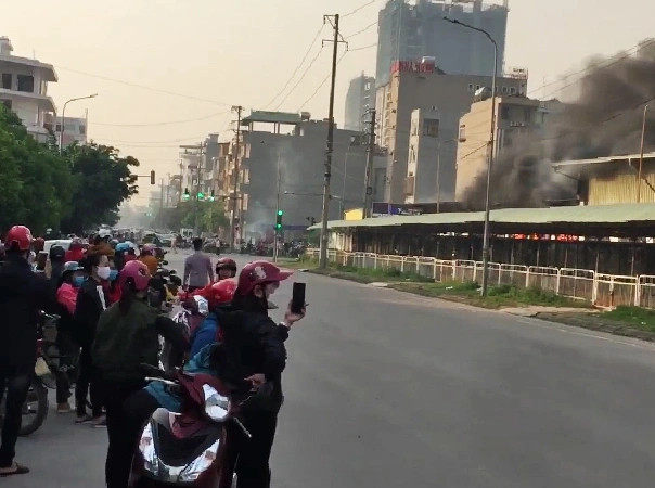 Hàng trăm công nhân cùng người dân tháo chạy, đứng phía ngoài doanh nghiệp này.