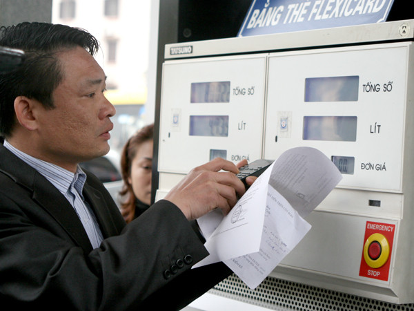 Kỹ thuật viên điều chỉnh lại mức giá tại các cột bơm xăng, dầu.