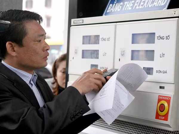 Kỹ thuật viên điều chỉnh lại mức giá tại các cột bơm xăng, dầu.