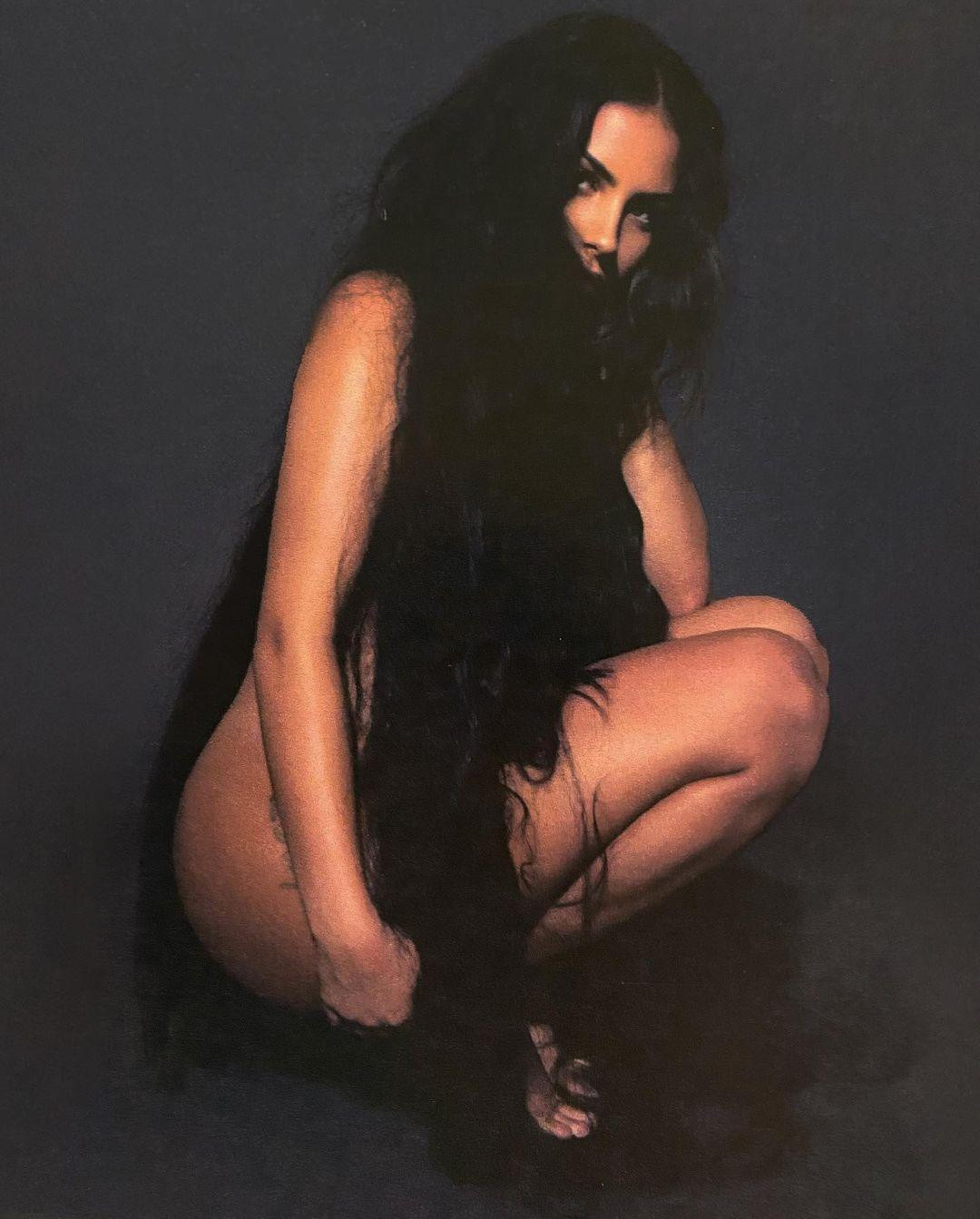 Ở bức ảnh khác, bạn gái Kanye West trong trạng thái khỏa thân, dùng tóc che đi những phần nhạy cảm, ánh mắt sắc lạnh nhìn về ống kính.