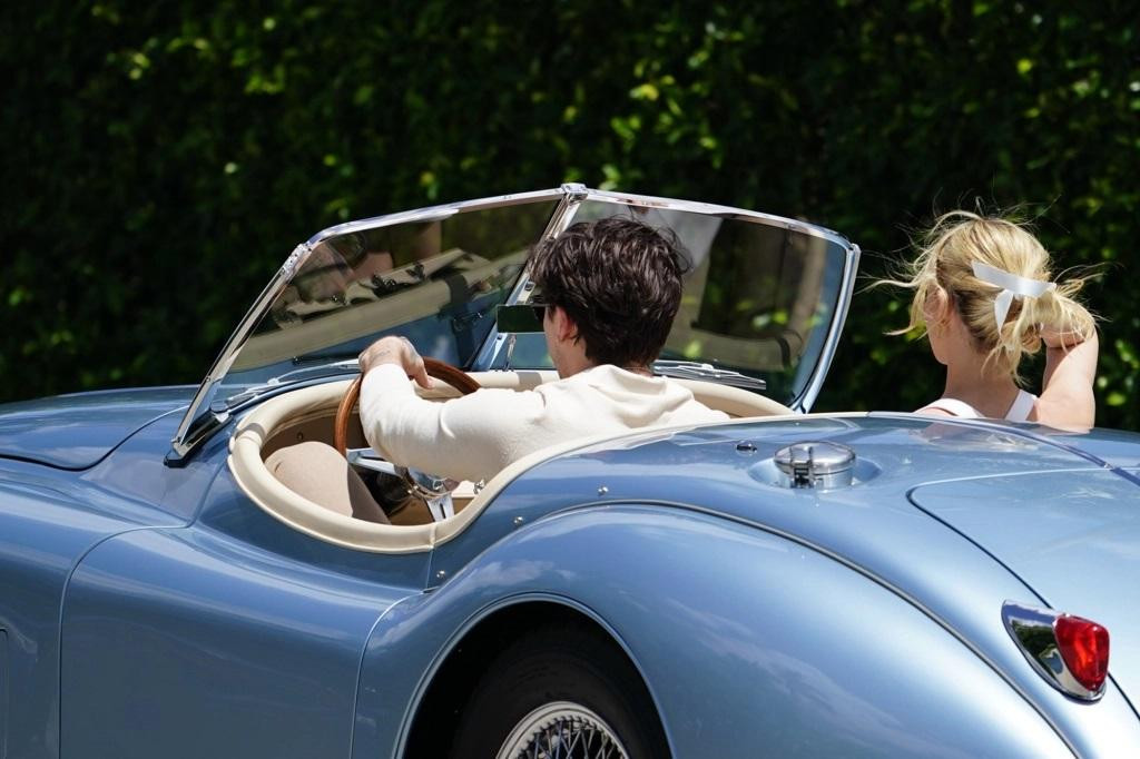 Cặp tân hôn đến tiệc sáng trên một chiếc xe Jaguar XK150S 1958 màu xanh nhạt.