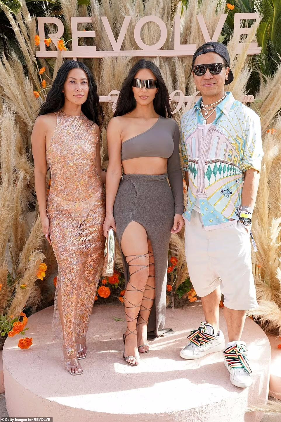 Kim Kardashian tôn thân hình "đồng hồ cát" trứ danh trong set váy hai mảnh bó sát. Chụp ảnh cùng cô là Giám đốc điều hành Revolve, Michael Mente và Giám đốc thương hiệu của Revolve, Raissa Gerona.