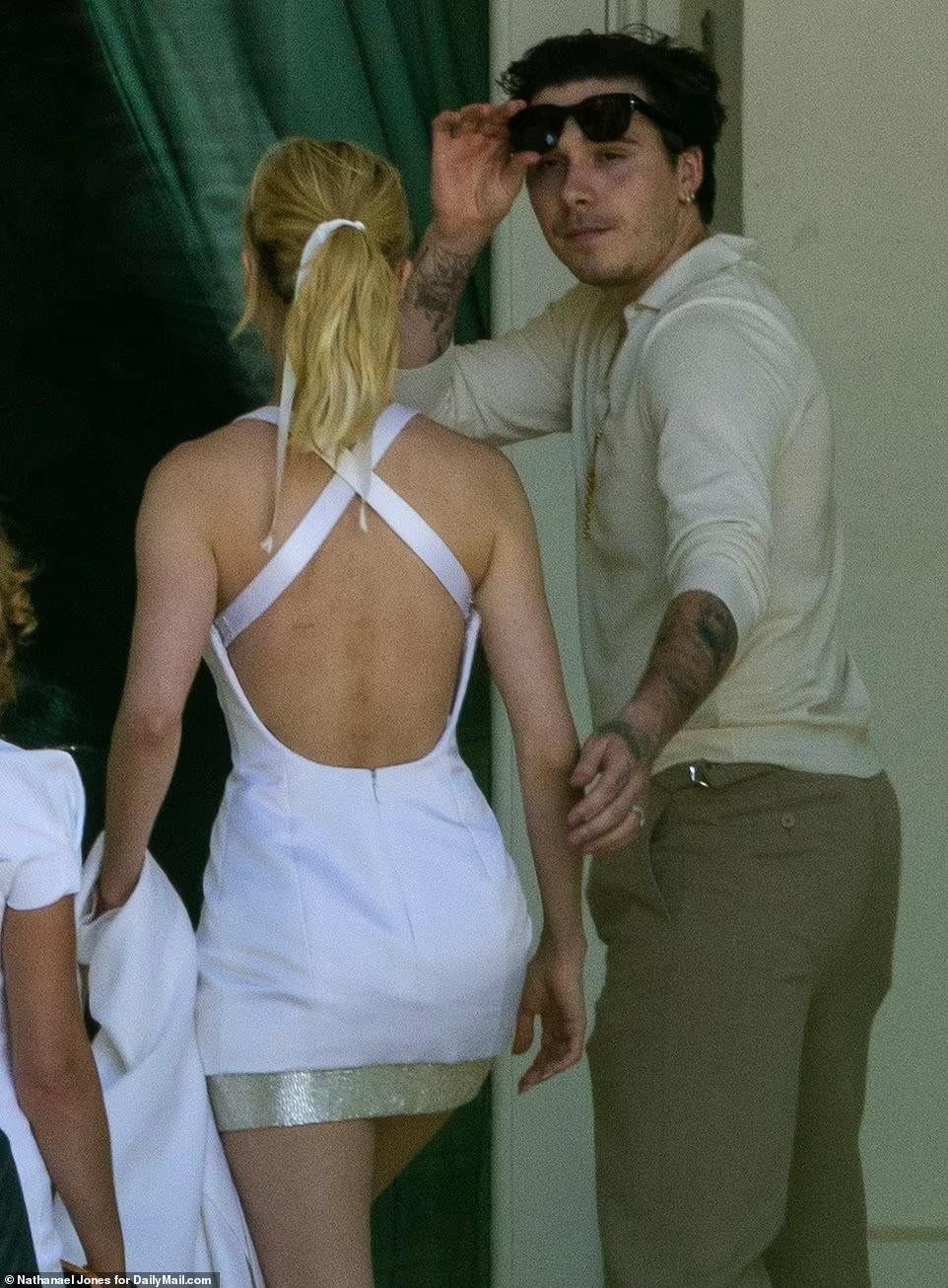 Brooklyn giản dị hơn với áo phông dài tay màu be và quần Tây nâu. Thua vợ 4 tuổi, nhưng xét về ngoại hình, cậu cả nhà Beckham trông già dặn hơn. Anh chứng minh là người chồng biết quan tâm khi liên tục dùng tay đỡ vợ.