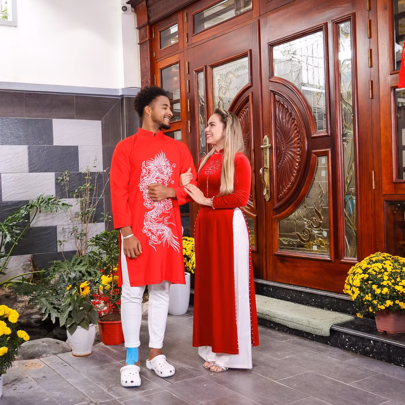 Vợ chồng cầu thủ Xuân Son - Marcele Seippel mặc áo dài truyền thống tông đỏ rực rỡ chào đón năm mới 2025.