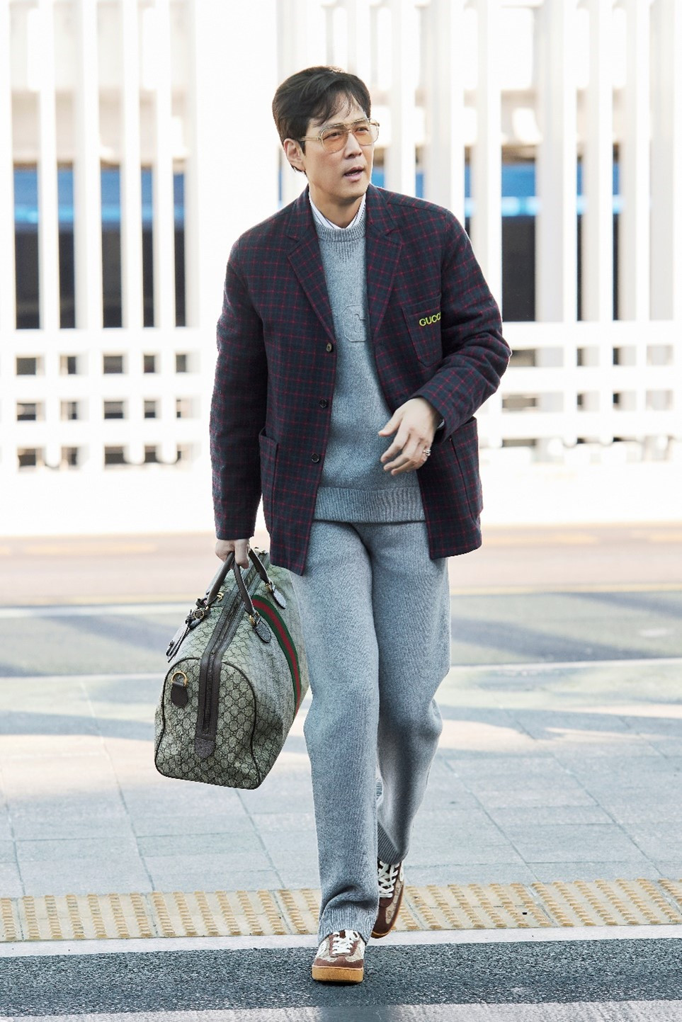 Tài tử Squid Game định hình phong cách &quot;giàu ngầm&quot; qua tông màu trang phục nhã nhặn, tạo điểm nhấn ở phụ kiện kính mắt, cà vạt sáng màu.