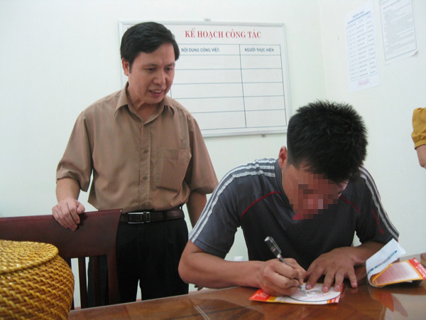 Ông Đinh Thế Cường, Phó Chánh Thanh tra Sở GD&ĐT Bắc Giang hướng dẫn anh Nguyễn Danh Ngọc ký tên lên bìa đĩa dữ liệu trước khi giao nộp cho cơ quan thanh tra Sở GD&ĐT