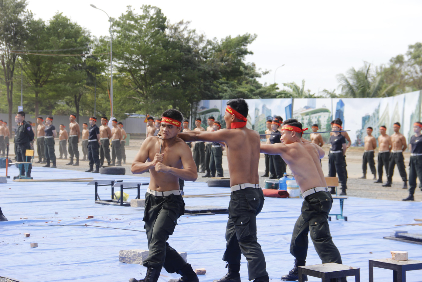 Nam cảnh sát biểu diễn tiết mục dùng cổ uốn cong thanh sắt. Nam cảnh sát biểu diễn tiết mục dùng cổ uốn cong thanh sắt.