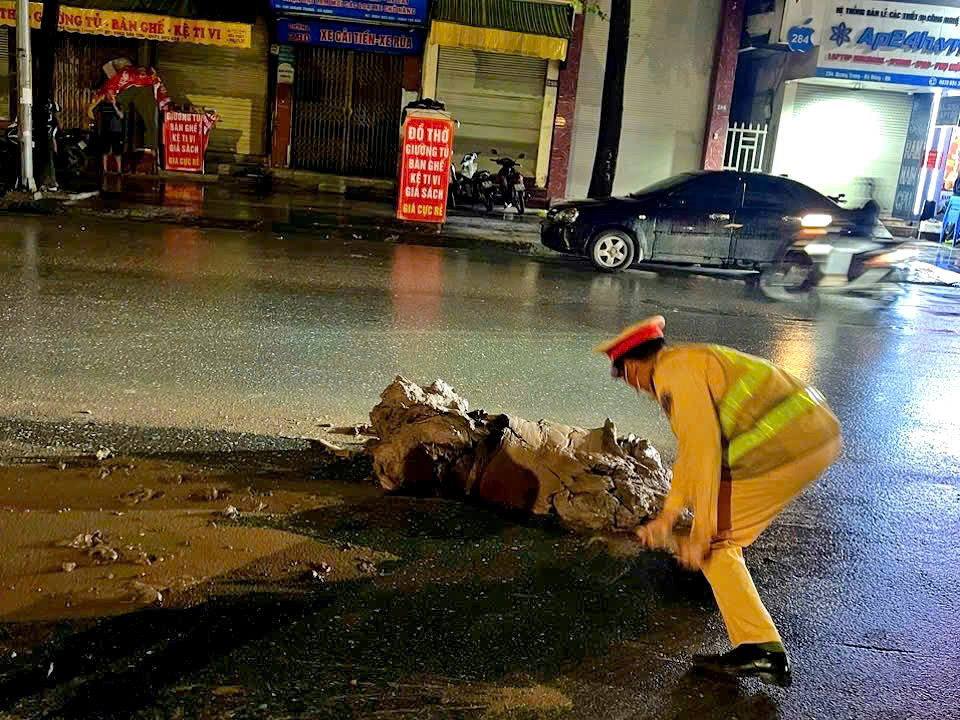 Lực lượng CSGT cảnh báo, phối hợp thu dọn đất bảo đảm an toàn giao thông.