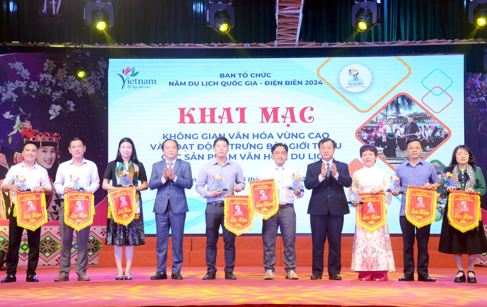 Phó Chủ tịch UBND tỉnh Điện Biên Vừ A Bằng trao cờ lưu niệm cho các đoàn tham gia trưng bày, giới thiệu văn hóa, du lịch.