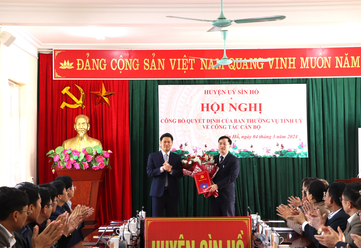 Phó Bí thư Thường trực Tỉnh ủy Lai Châu Vũ Mạnh Hà trao Quyết định và tặng hoa chúc mừng tân Phó Bí thư Huyện ủy Sìn Hồ Trần Văn Sứng.