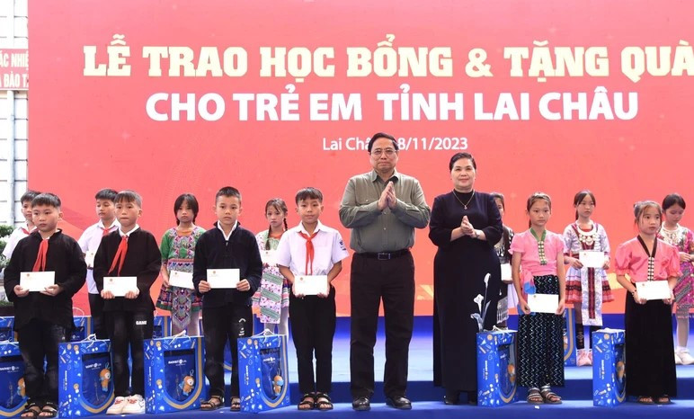 Thủ tướng Chính phủ Phạm Minh Chính và Bí thư Tỉnh ủy Lai Châu Giàng Páo Mỷ trao quà, học bổng tặng các học sinh. (Ảnh: Báo Nhân dân)